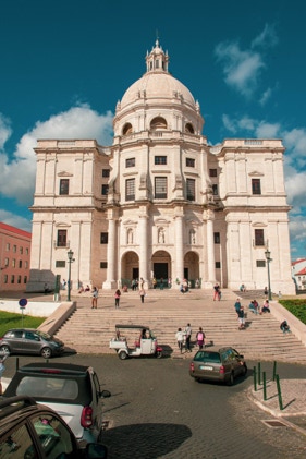 Creme colored court house shaped building located in Lisbon, Portugal. Clear, beautiful afternoon sky, with many tourists on the grand steps of the building. Photographed by Tiago with the Shots.